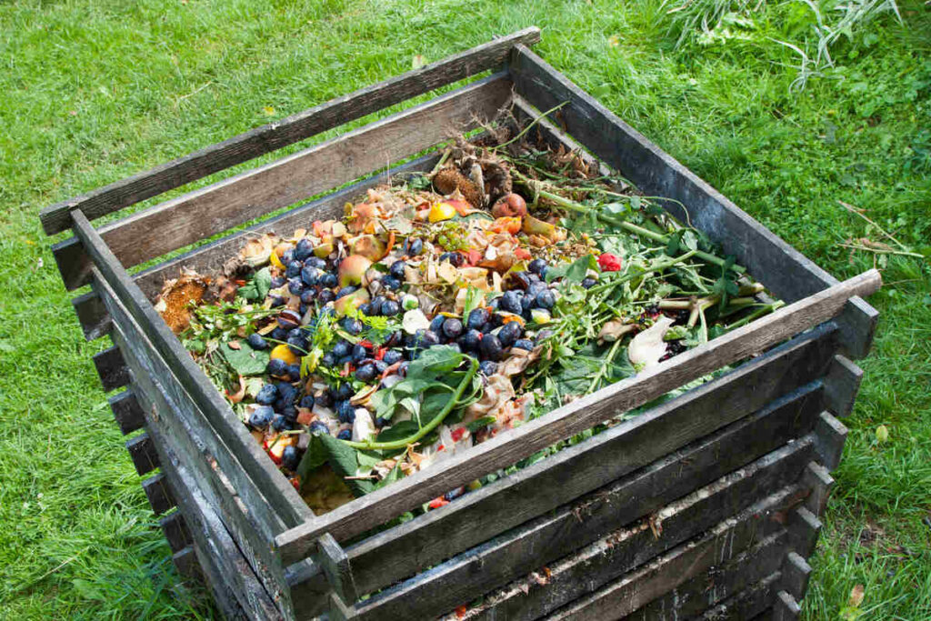 Compost bin providing aeration filled with vegetable matter and yard waste